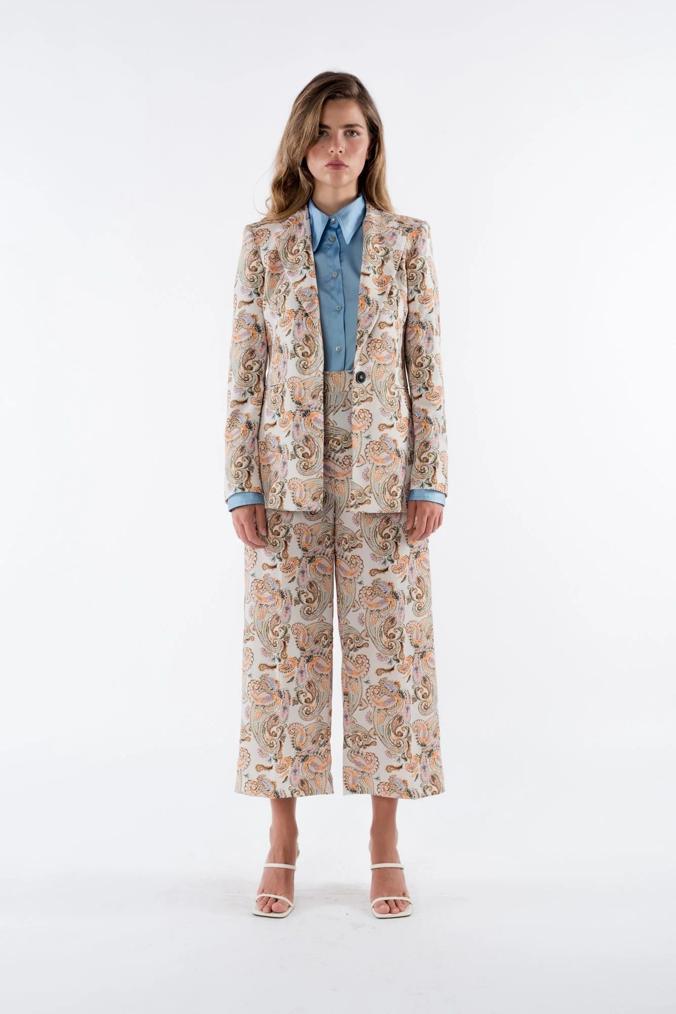 Présentation complète d'un blazer femme imprimé paisley beige, associé à un chemisier bleu, mettant en valeur les détails raffinés de ce blazer fleuri femme.