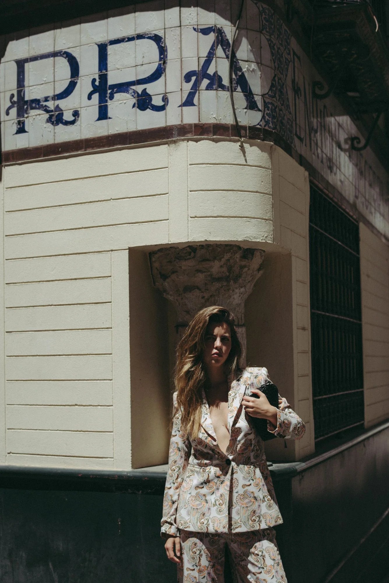 Modèle portant un blazer femme imprimé paisley beige, mettant en avant la coupe moderne et chic, dans un environnement urbain. Blazer fleuri femme pour un style élégant.