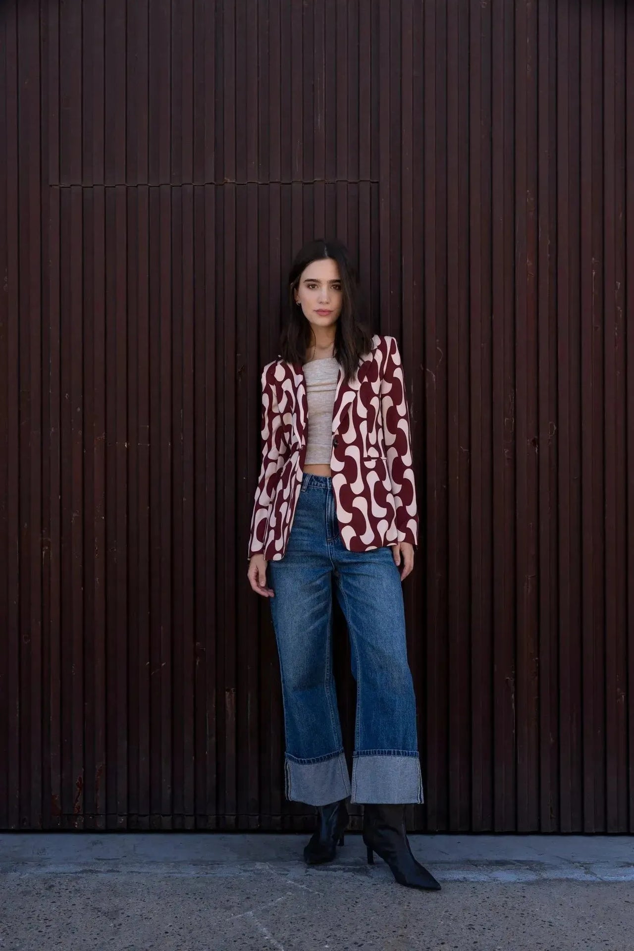 Femme posant avec un blazer imprimé tendance femme chic, associé à un haut beige et un jean, démontrant l'élégance et l'originalité du blazer motif femme.