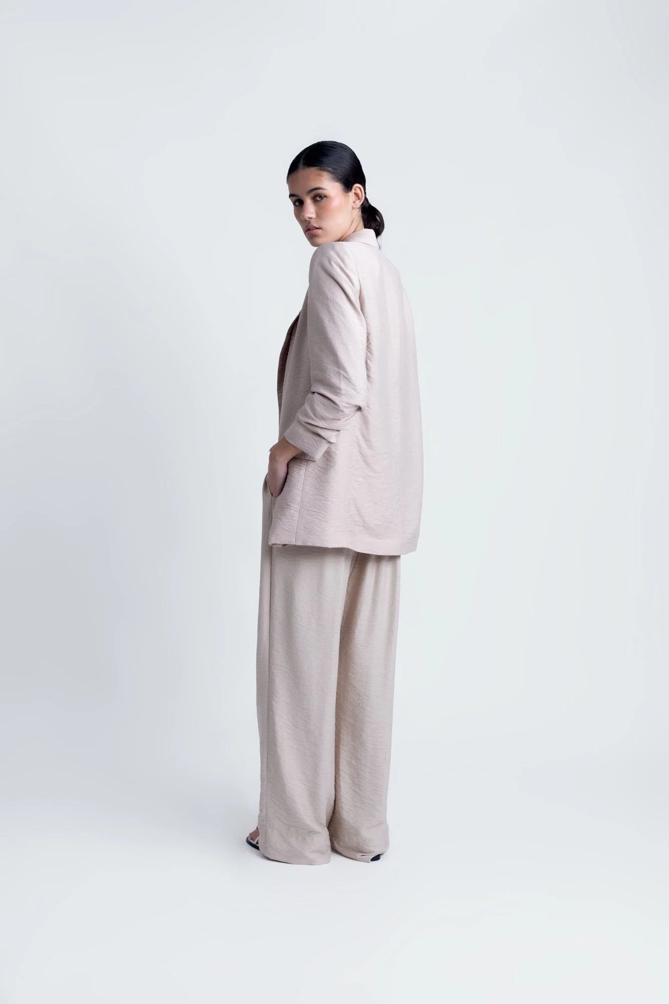Femme portant un blazer texturé beige et pantalon large pour un look élégant