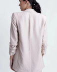 Femme retournée, mettant en valeur la Veste Légère Femme Beige Texturée Oversize à Épaules Structurées, Style Casual Chic.