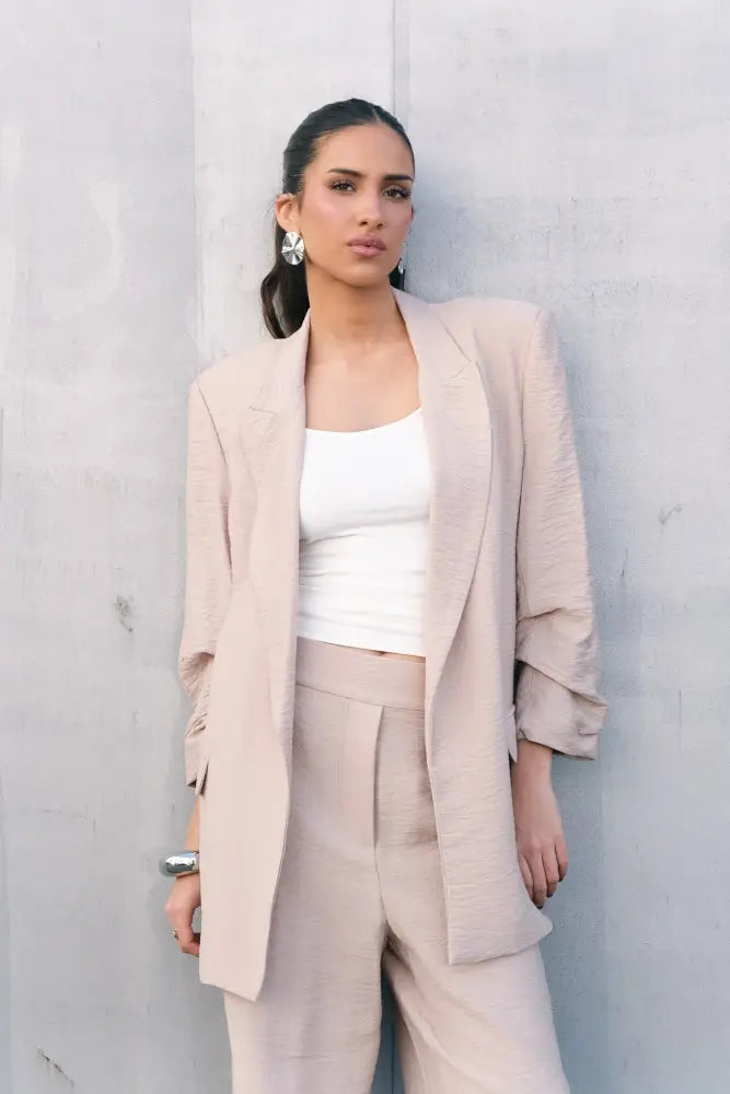 Blazer texturé beige avec pantalon assorti porté sur un haut blanc, style élégant