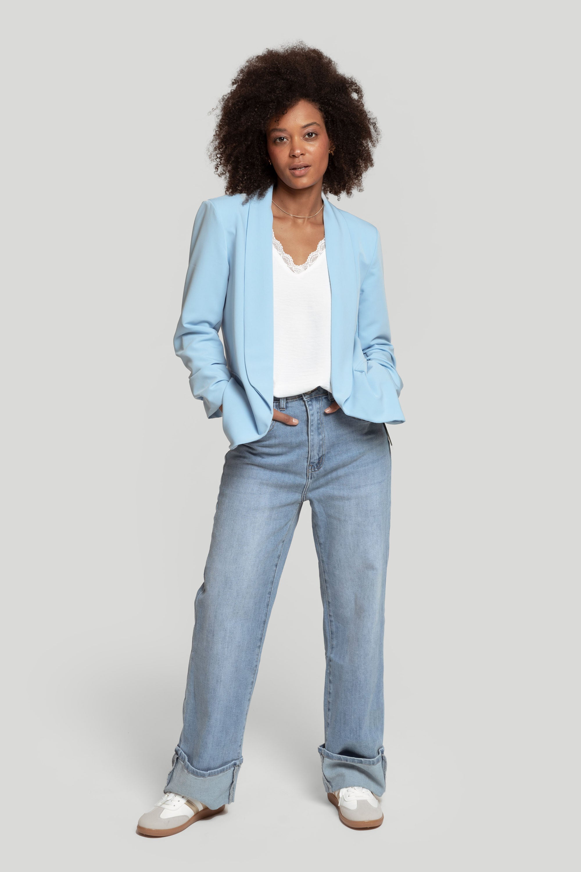 Profil d'un modèle portant un blazer femme chic bleu clair, accentuant la style contemporain.