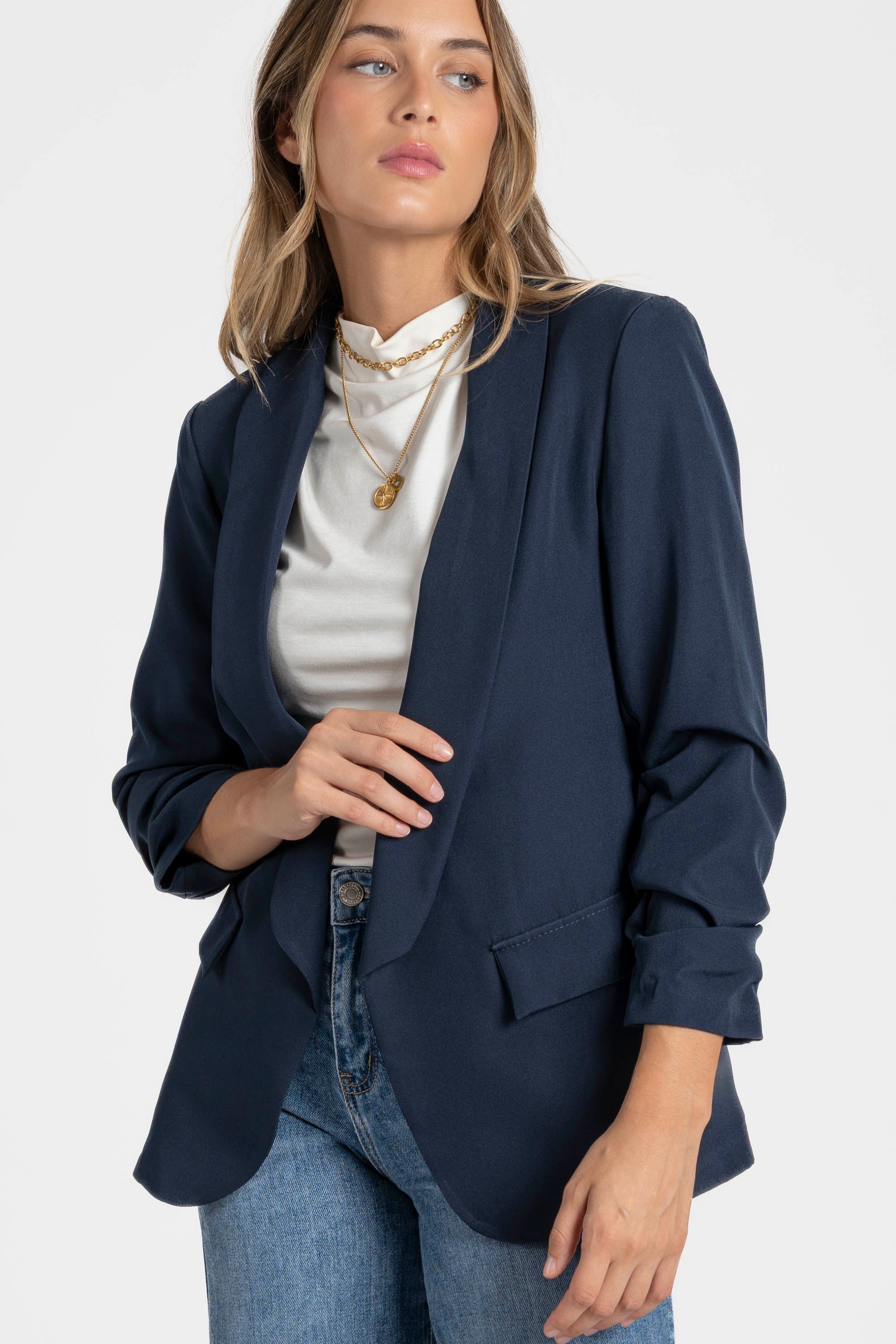 Zoom sur un modèle avec un blazer femme chic bleu marine, ajoutant une touche professionnelle.