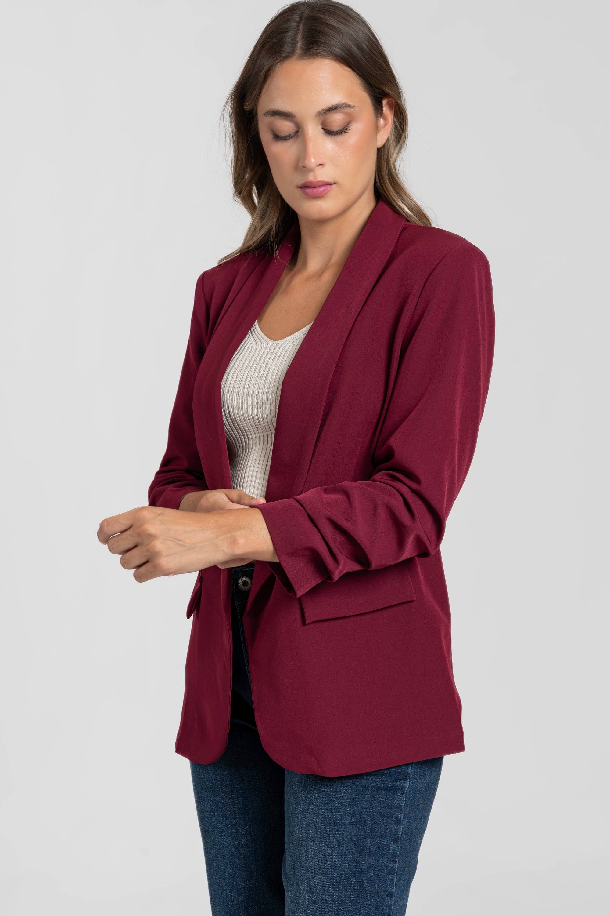 Mannequin tourné vers la droite portant un blazer femme chic bordeaux, soulignant les détails des manches froncées.