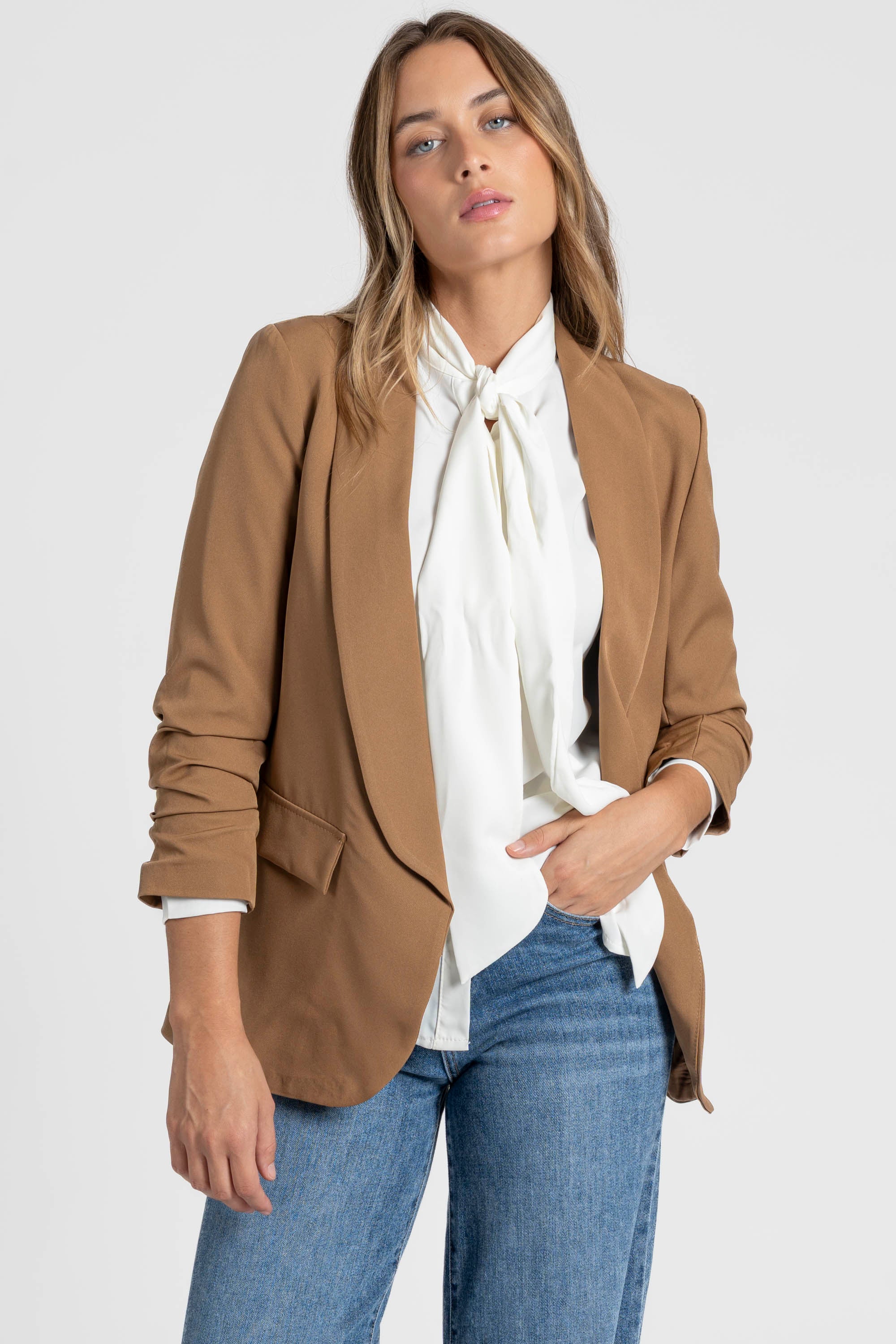 Zoom sur un modèle féminin avec un blazer femme chic marron, créant une allure élégante.