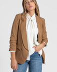 Zoom sur un modèle féminin avec un blazer femme chic marron, créant une allure élégante.