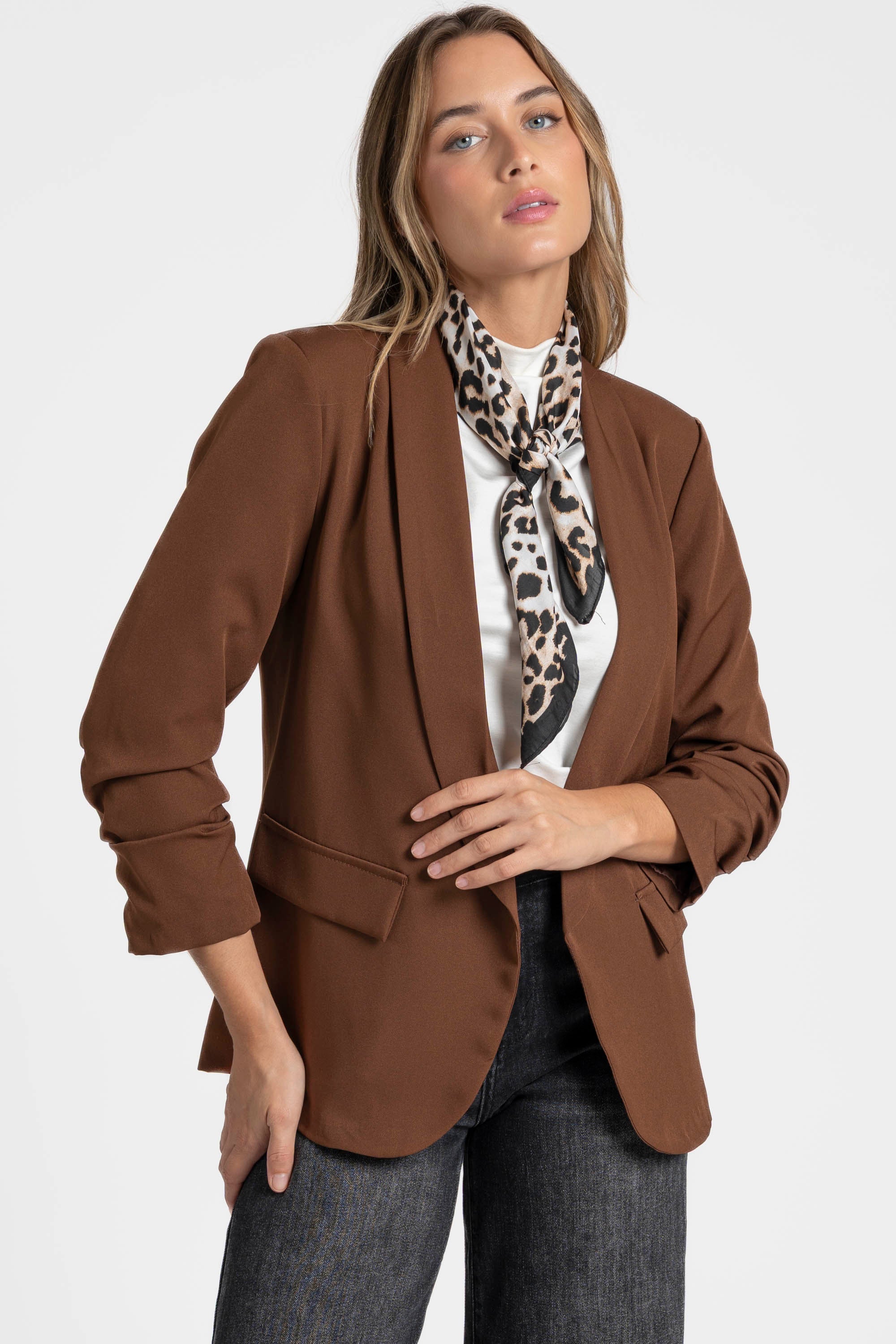 Détail d'un blazer femme chic marron mis en avant sur une femme avec un style moderne.