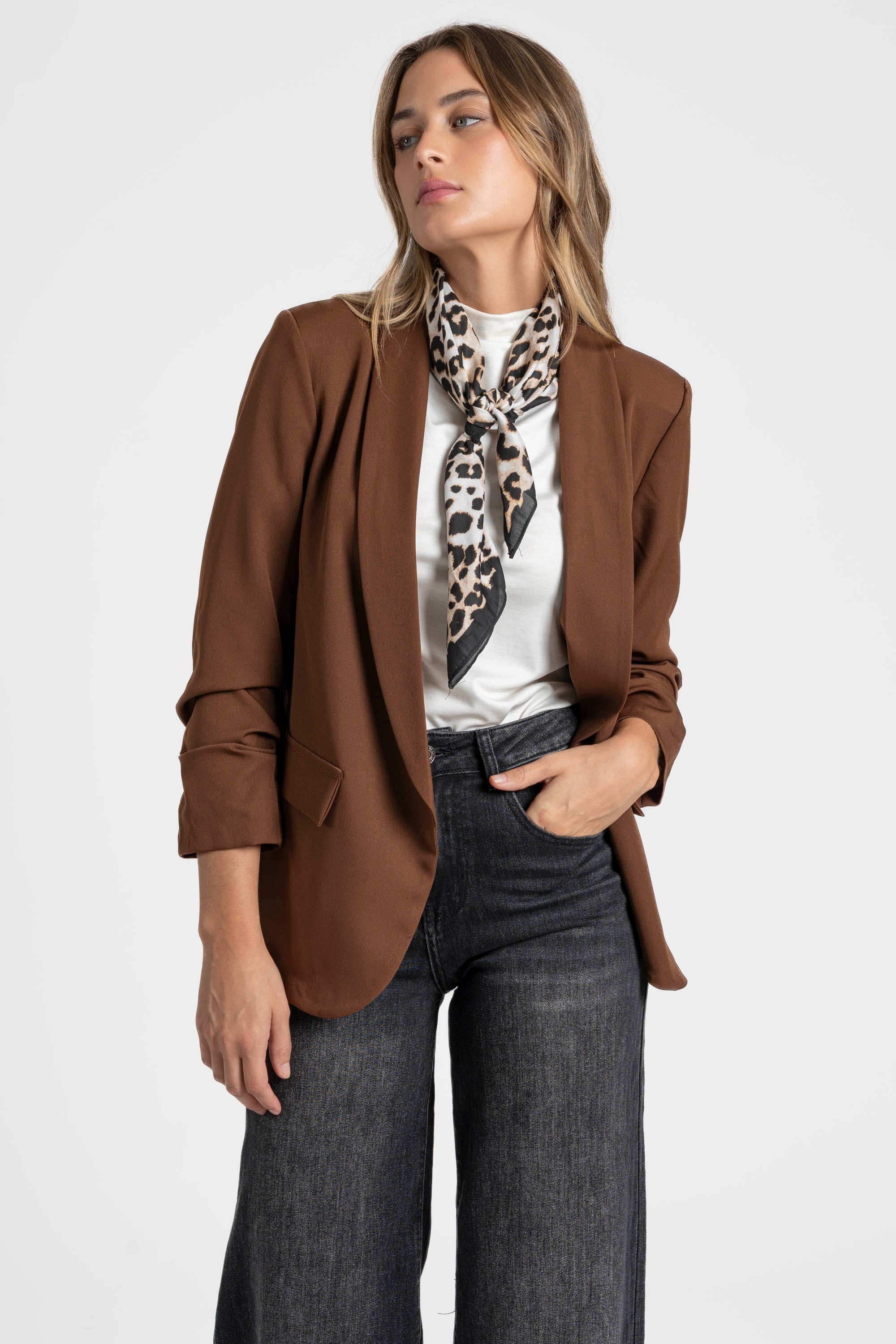 Femme présentant un blazer femme chic marron, accompagnée d'un foulard tacheté pour un look élégant.