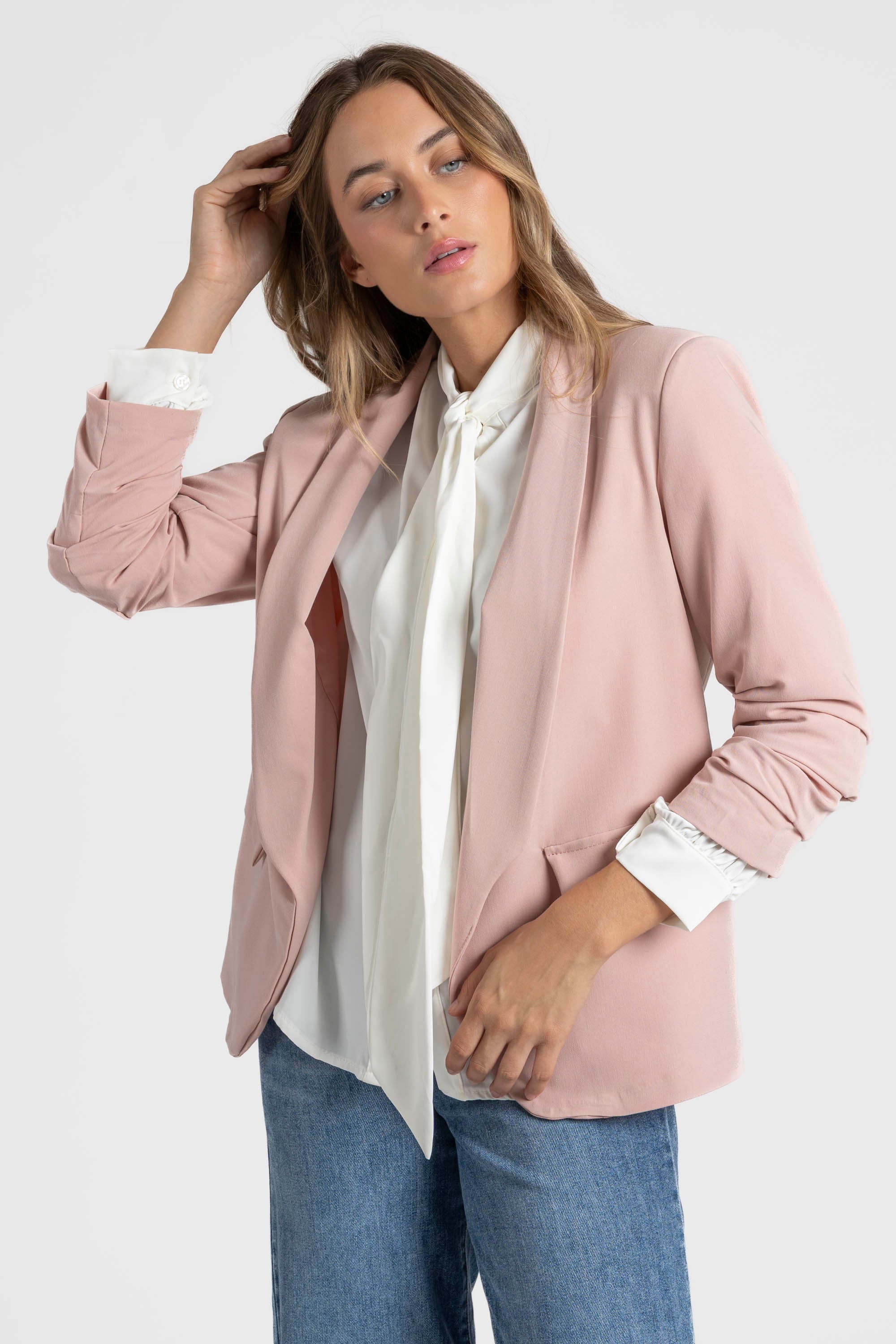 Profil d'un modèle portant un blazer femme chic rose, créé pour un look habillé.