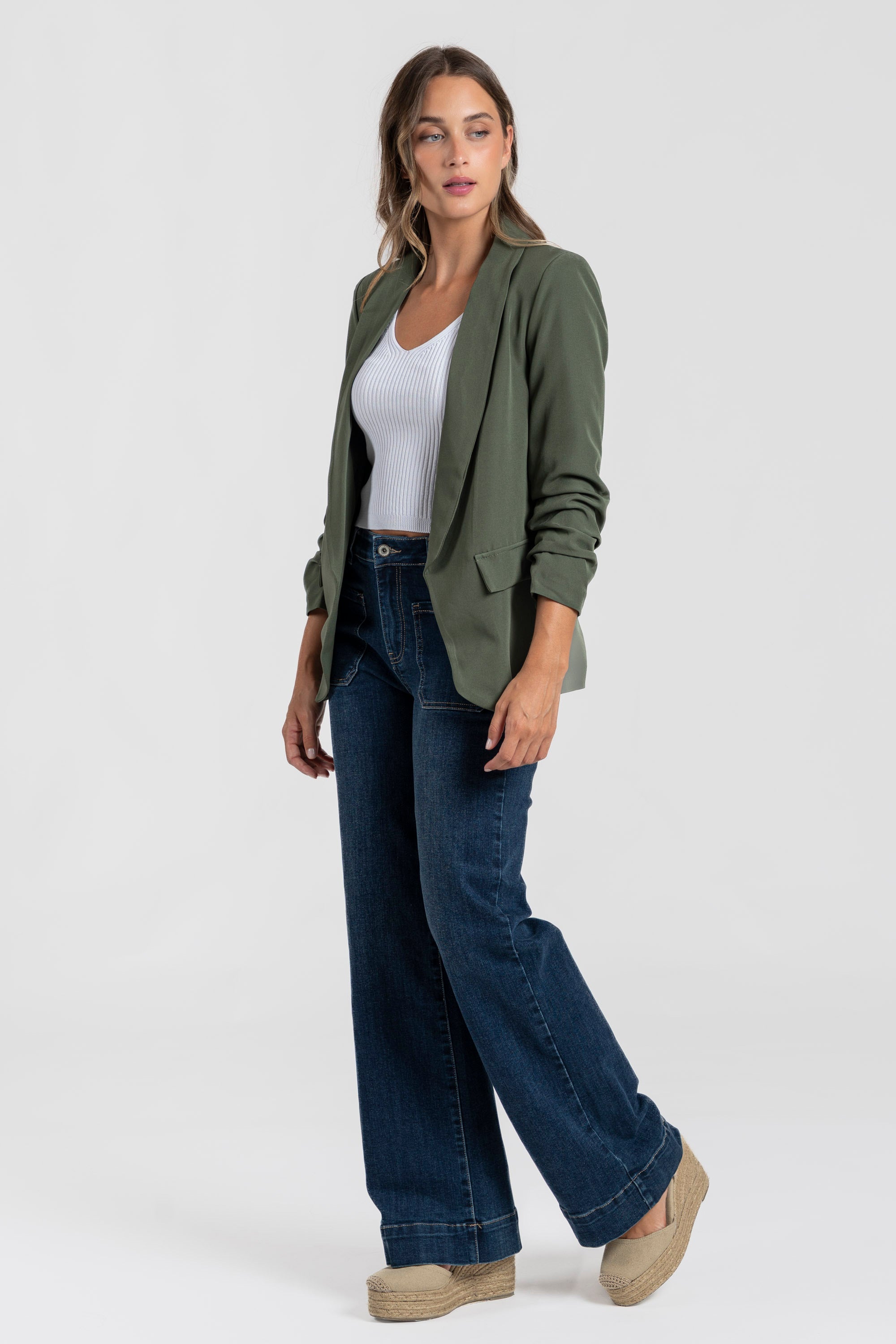 Modèle en blazer femme chic vert, complété par un pantalon large pour un style casual.