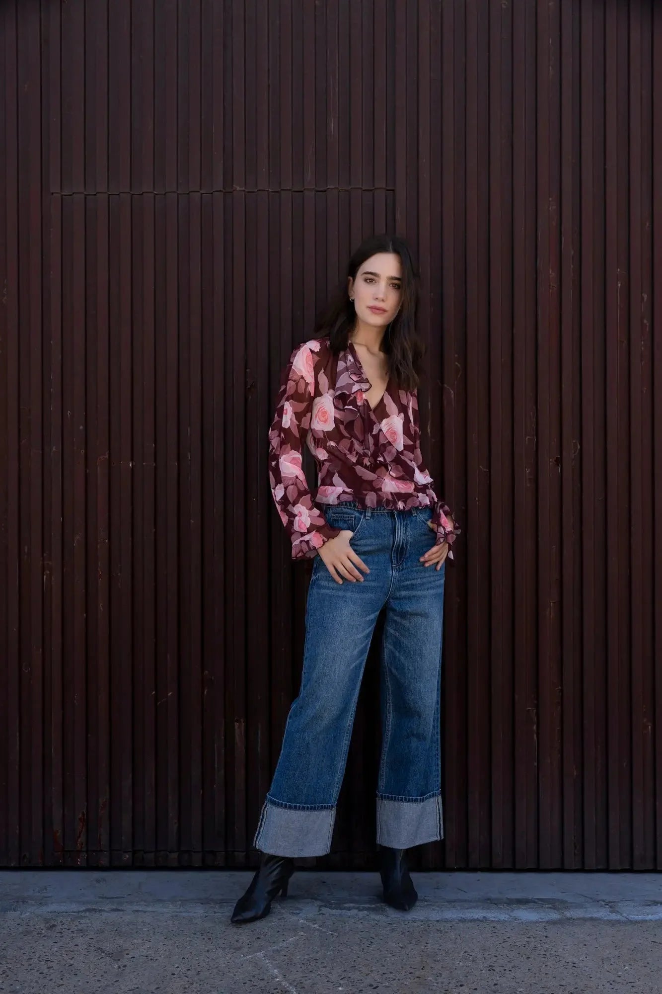 Femme portant une blouse à volants imprimée florale, jeans et bottines noires