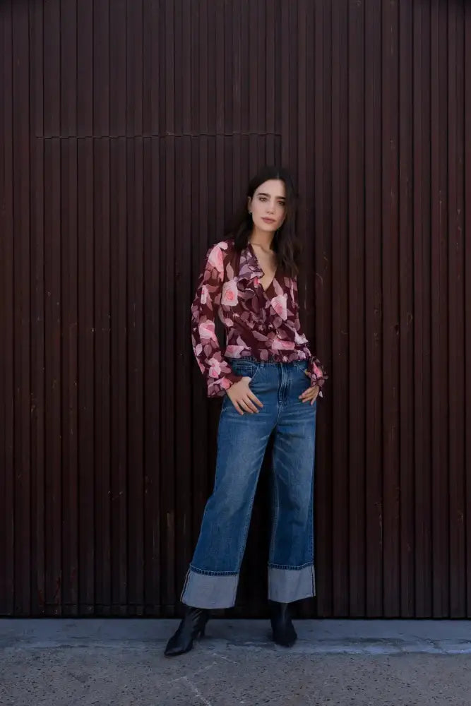 Femme portant une blouse à volants imprimée florale, jeans et bottines noires