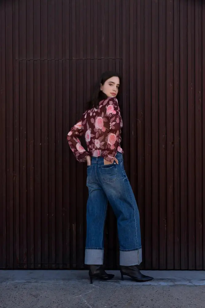Femme portant une blouse à volants imprimée florale, jeans retroussé et bottines noires