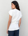 Femme de dos en blouse blanche élégante, montrant le design moderne au niveau du dos, idéal pour un look tendance. Cette blouse blanche femme est un must-have.