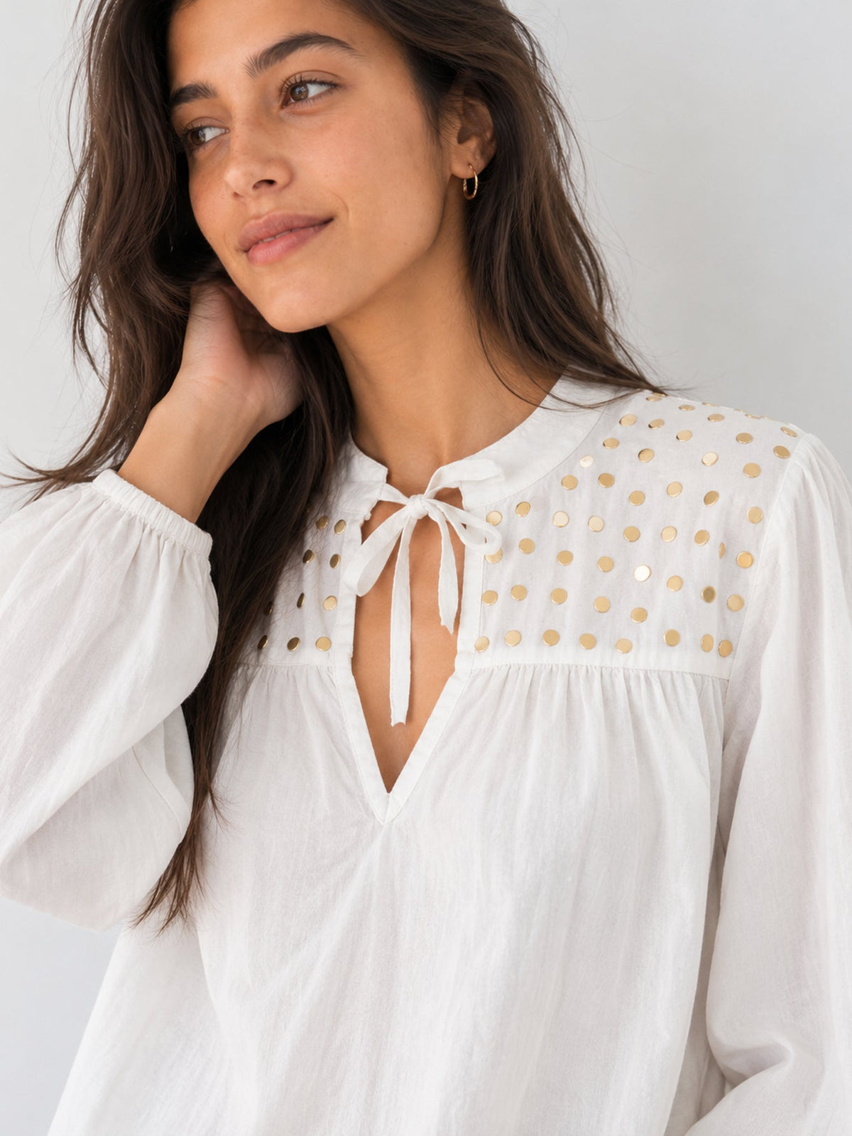 Détail encolure V sur blouse blanche pastilles dorées
