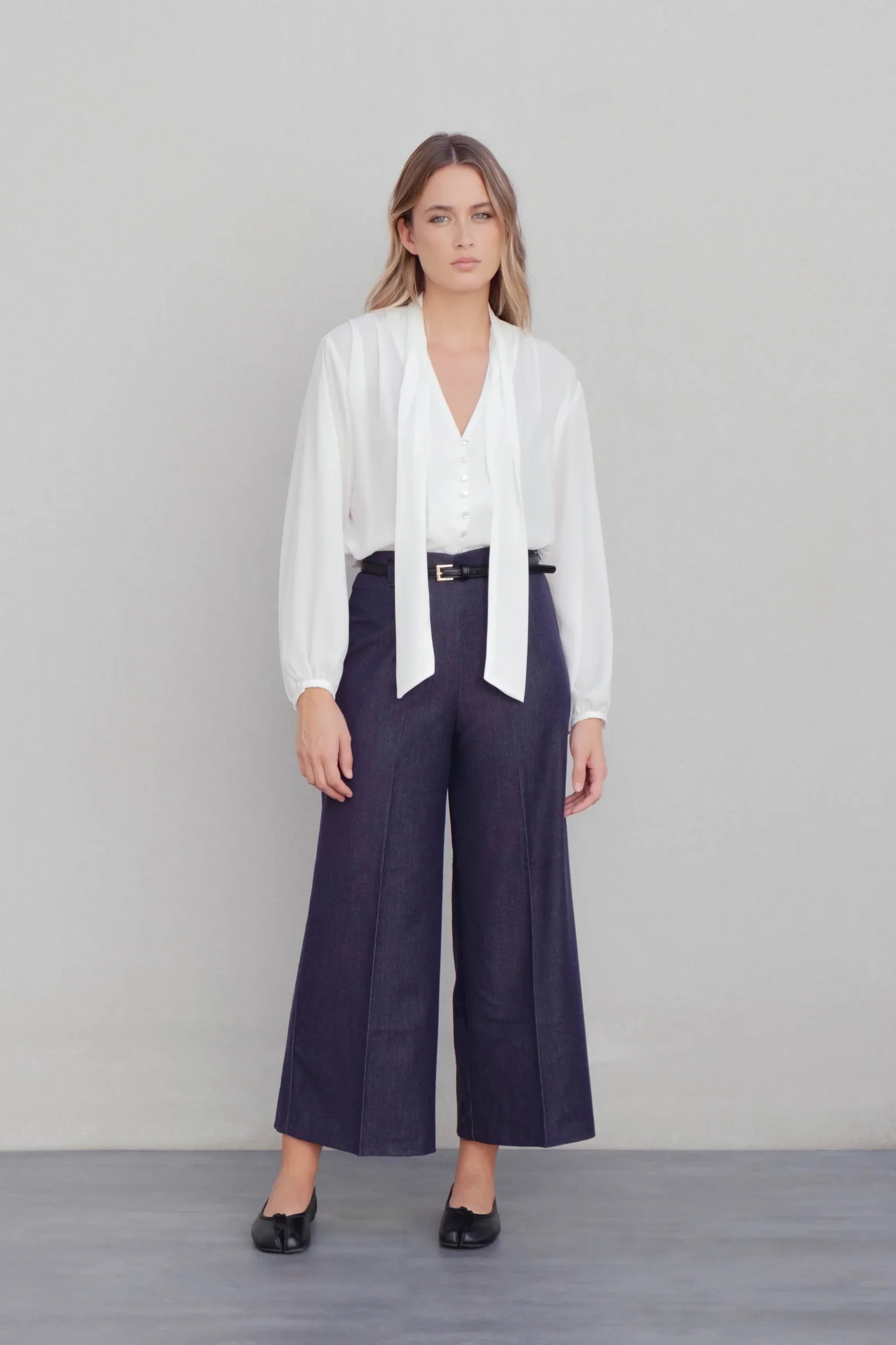 Alt texte d’une blouse fluide élégante blanche à nouer avec pantalon large bleu foncé