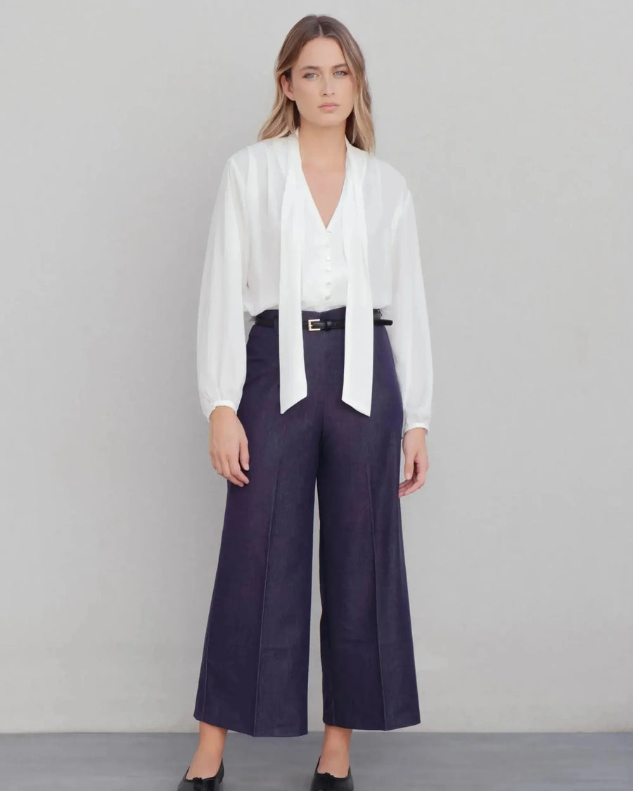 Alt texte d’une blouse fluide élégante blanche à nouer avec pantalon large bleu foncé