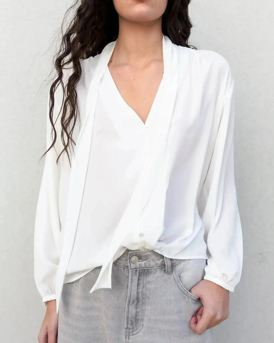 Femme portant une blouse fluide élégante blanche à nouer, livraison rapide
