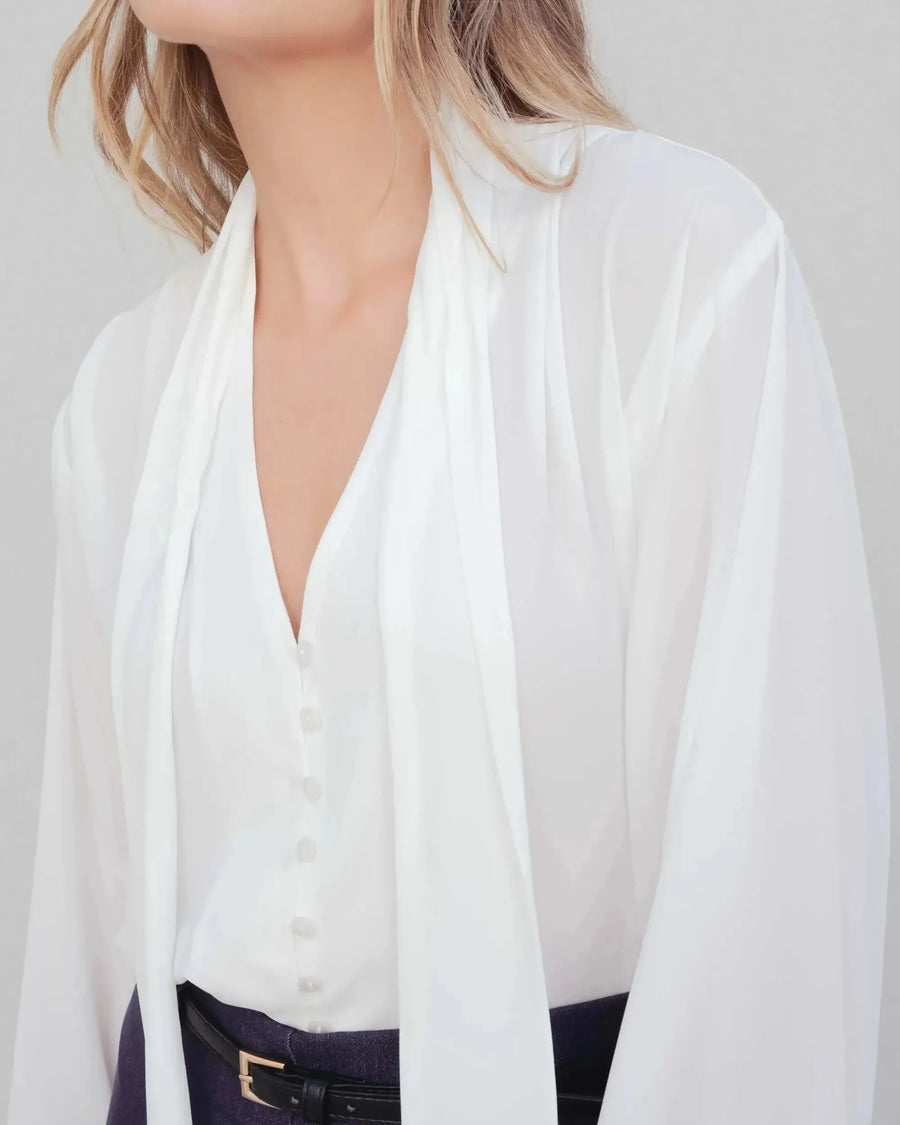 Femme portant une blouse fluide élégante blanche à nouer, livraison rapide