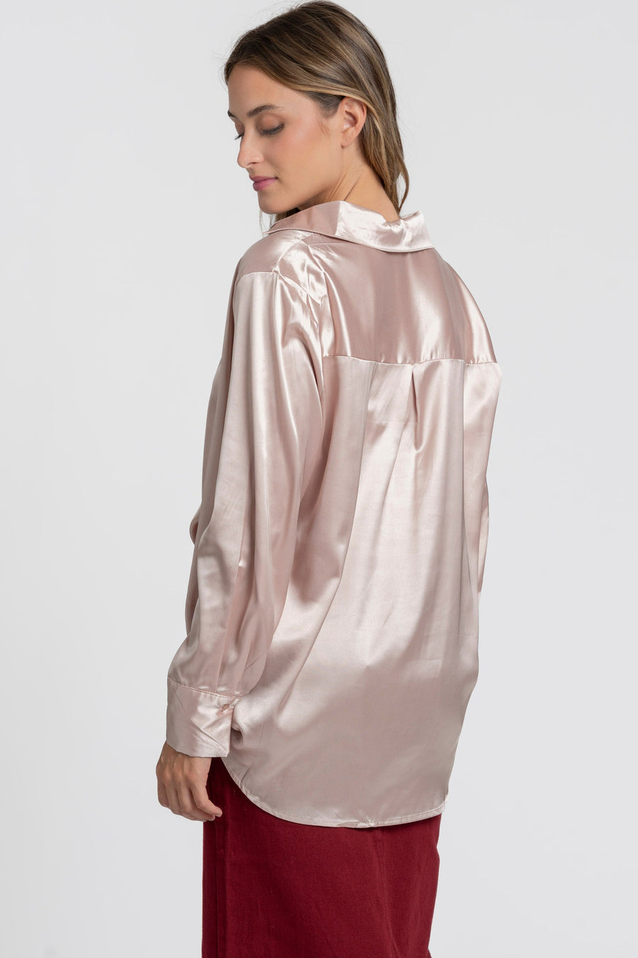 Détails du dos d'une blouse satinée femme élégante, avec col chemise, montrant son drapé fluide sur un modèle.