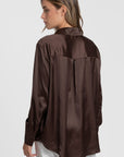 Détails du dos d'une blouse satinée femme élégante en brun, montrant le col chemise et la coupe ample.