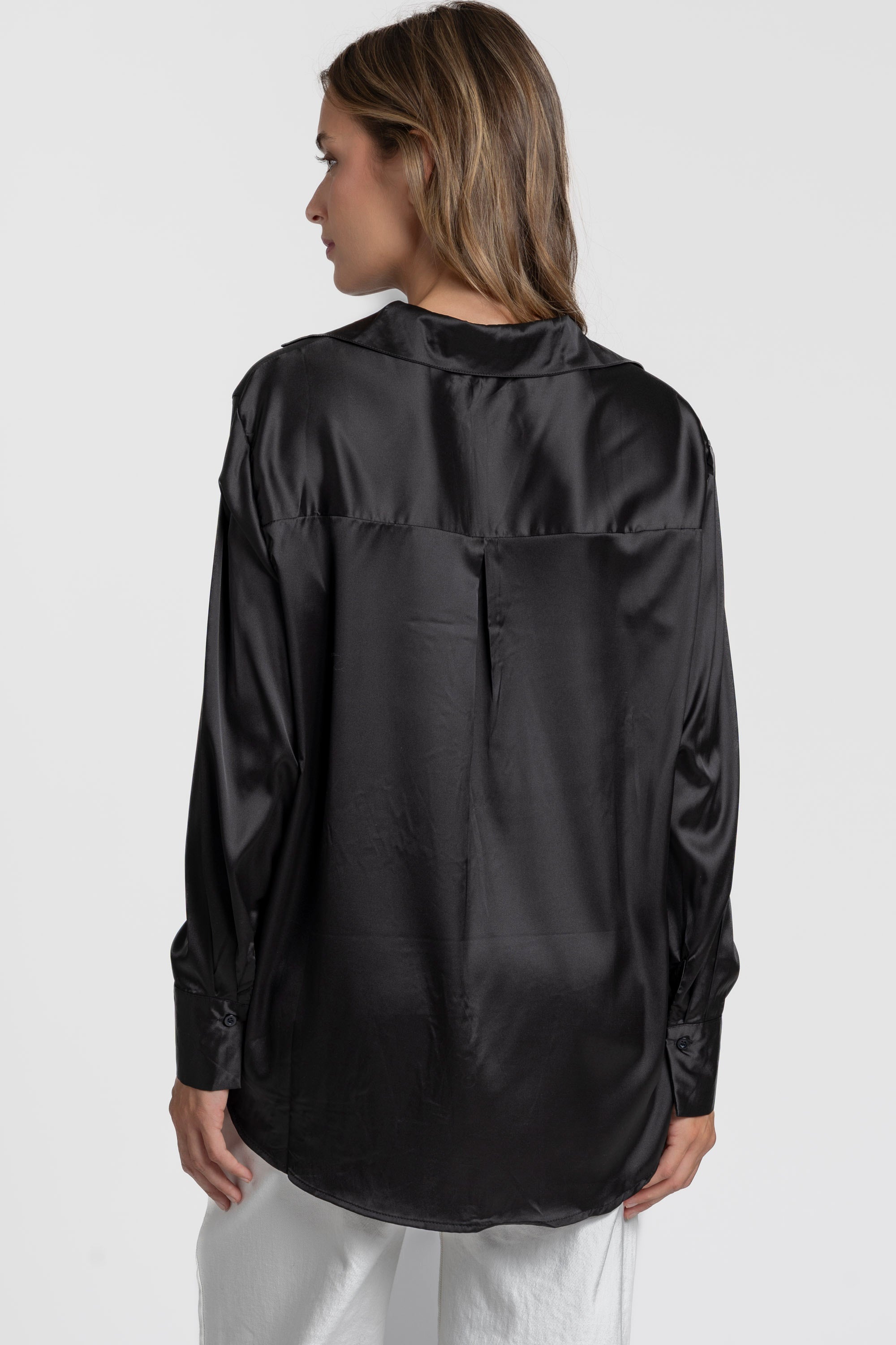 Vue arrière d'une blouse satinée femme élégante, en noir, mettant en avant le col chemise et la finition soignée.