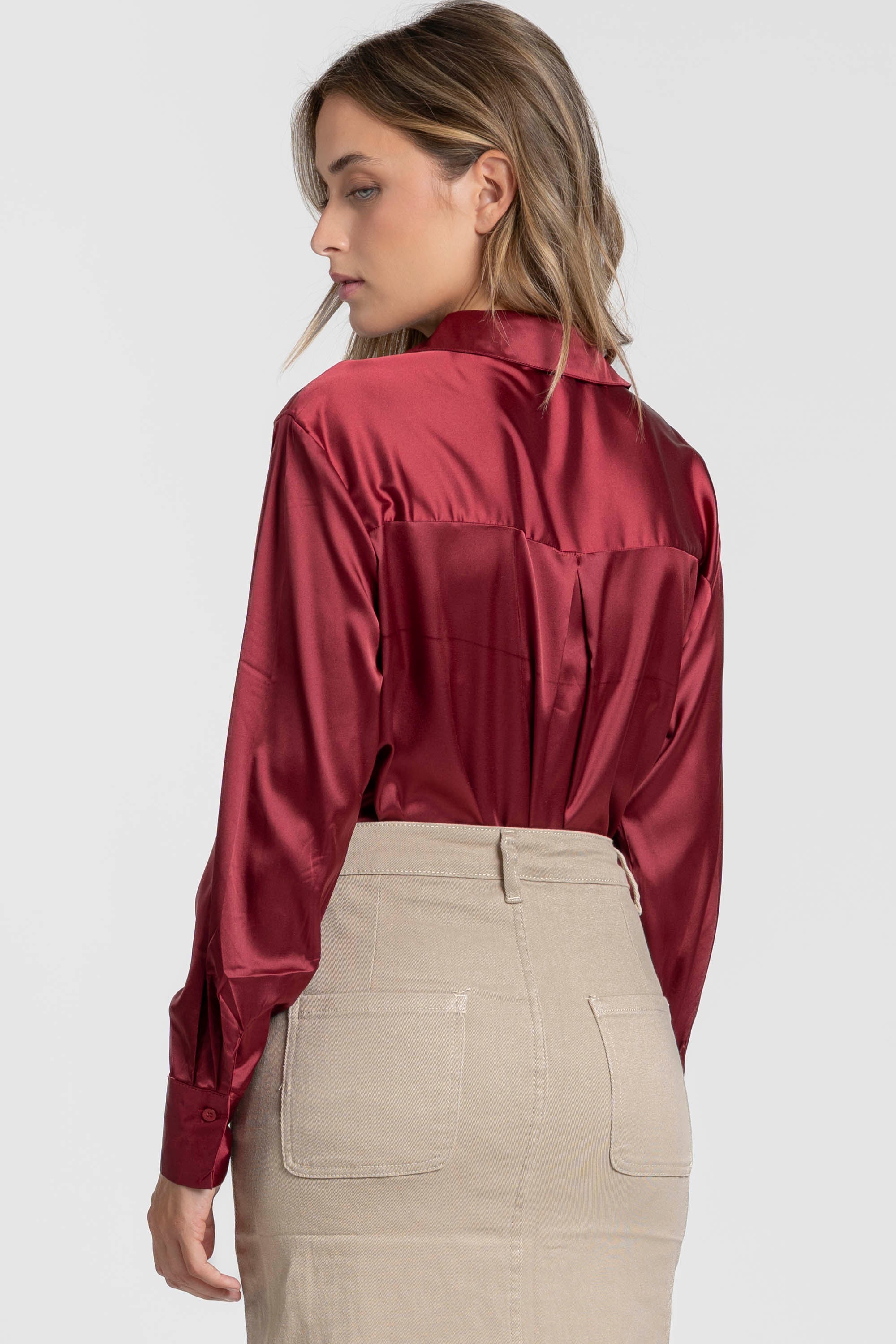 Détails du dos d'une blouse satinée femme élégante en rouge, mettant en avant le col chemise et le drapé fluide.