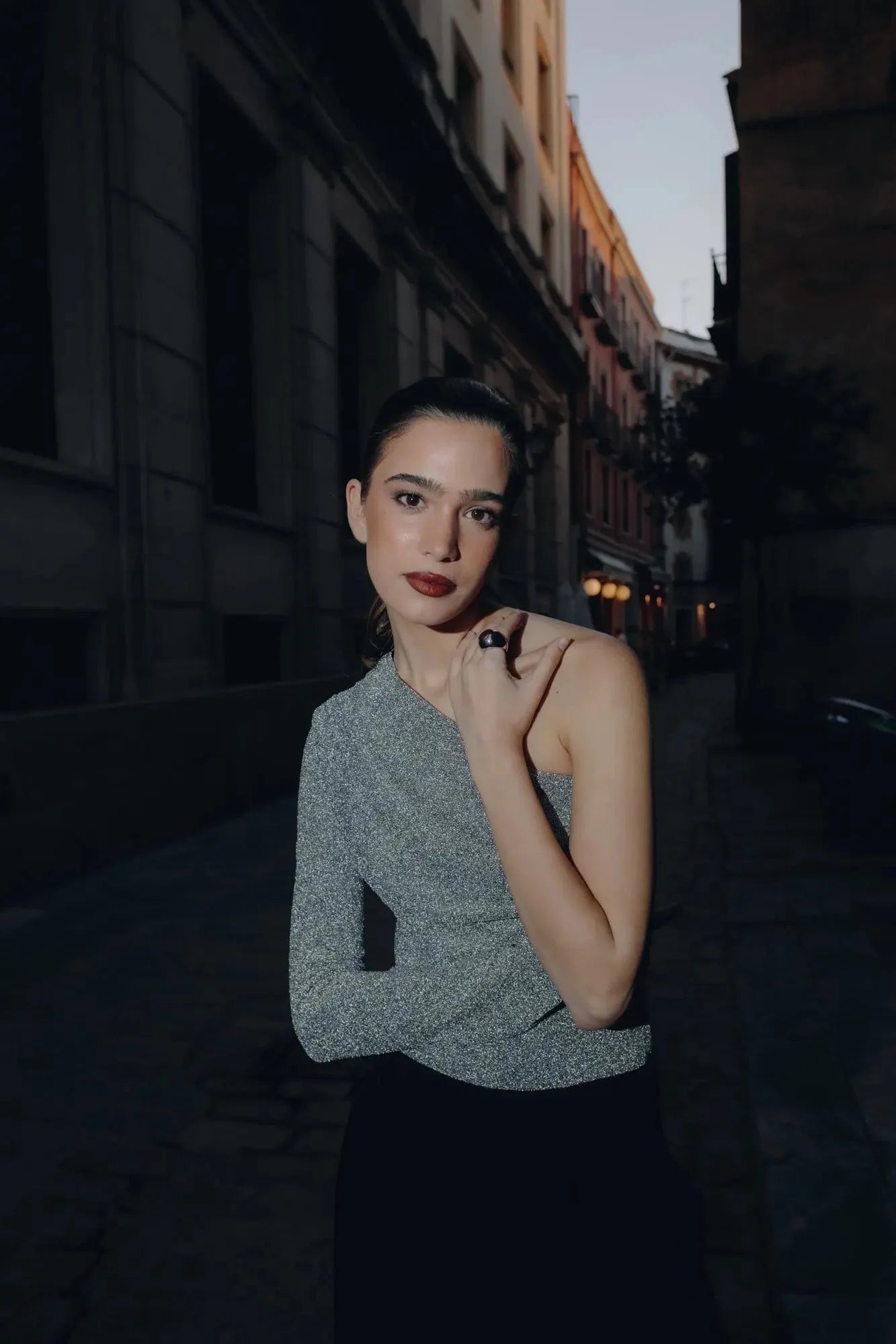 Modèle avec un body asymétrique, au look épuré, mettant en avant un style sophistiqué dans une ambiance urbaine.