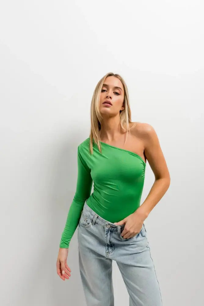 Body asymétrique vert à manches longues porté par une femme avec jeans clair