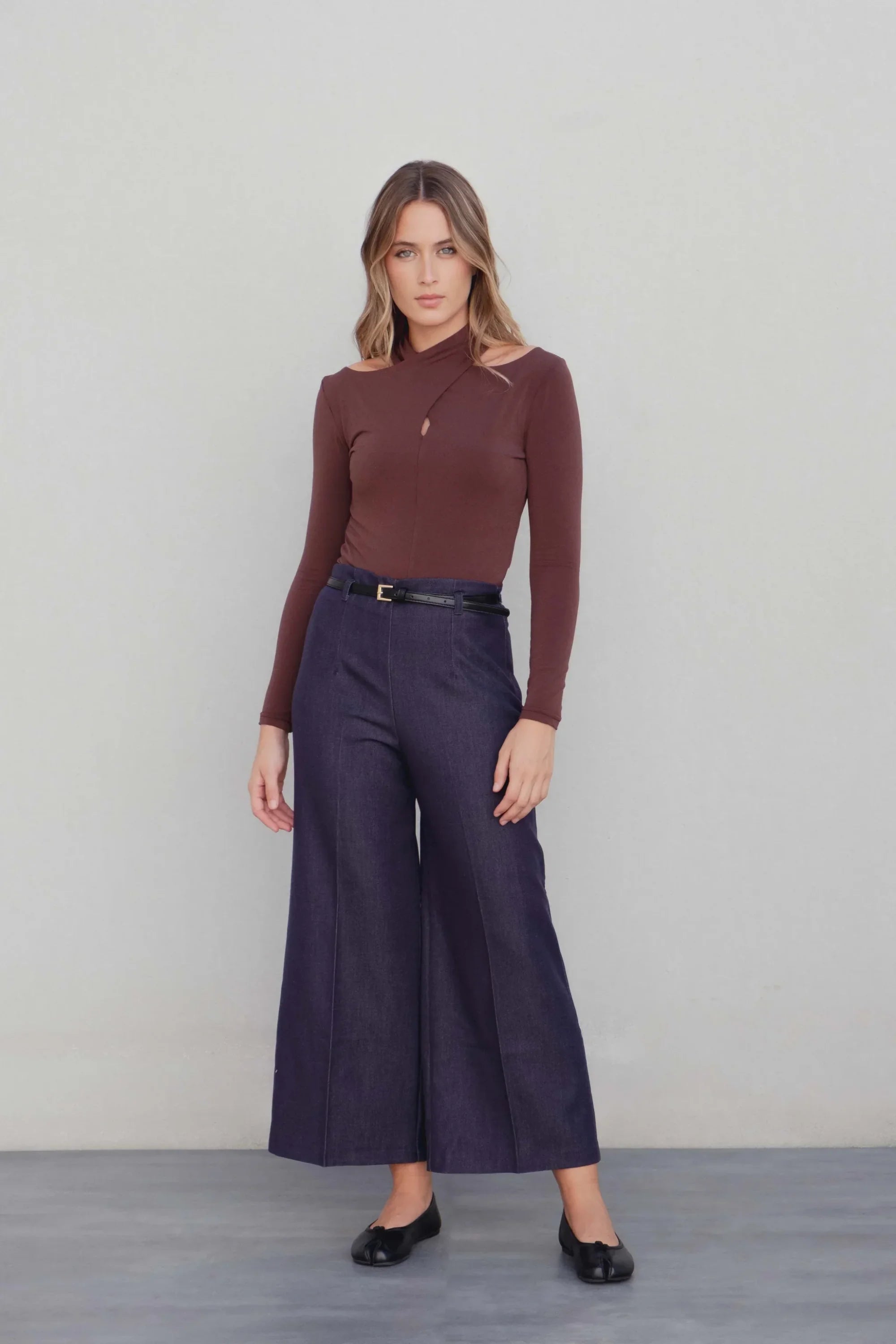 Body femme drapé marron avec col croisé, manches longues, épaules dénudées et pantalon cropped bleu foncé