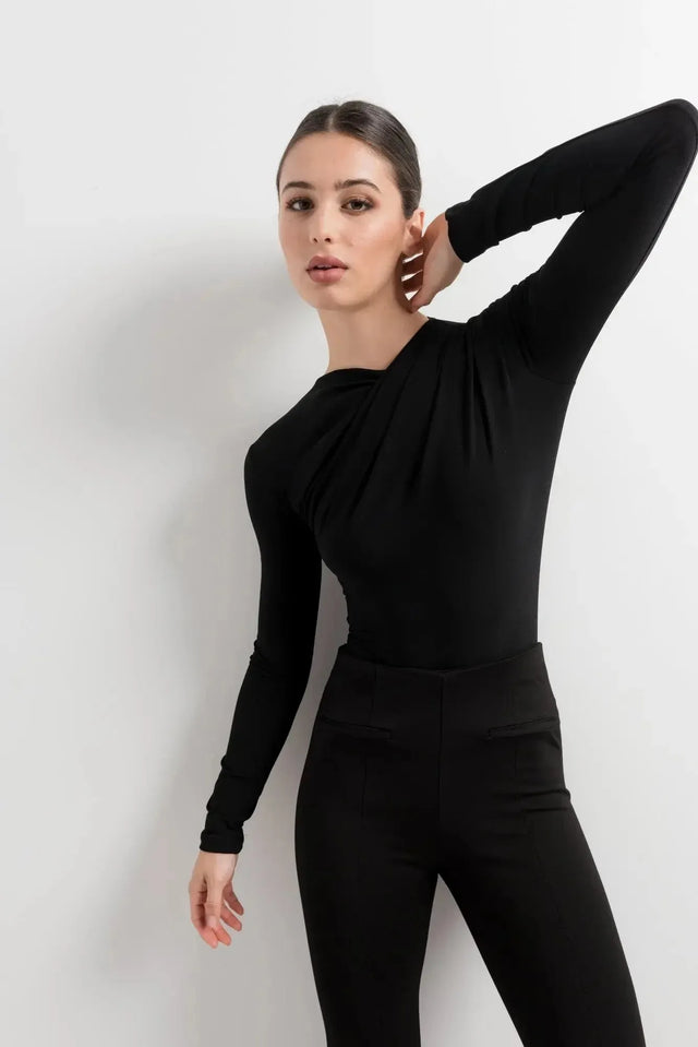 Body Drapé Noir Style et Confort Réunis - Femme prenant une pose élégante, habillée d'un body manche longue femme, sur fond neutre, soulignant son chic intemporel.