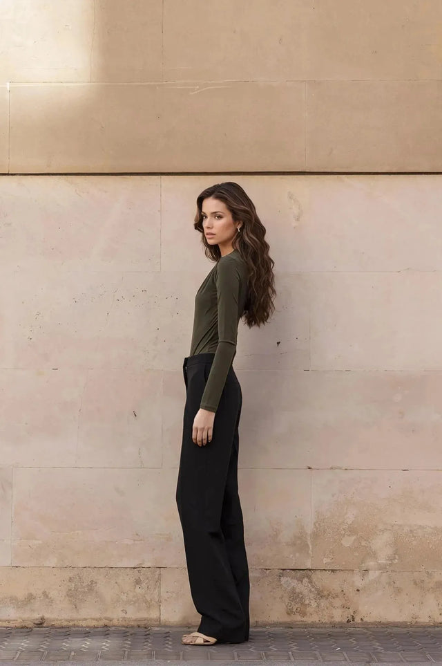 Vue latérale du modèle portant un body vert olive avec drapé, mettant en avant un look élégant.