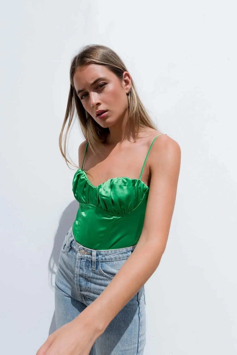 Gros plan sur un Body Satin Vert Effet Corset, mettant en valeur son style chic. Idéal pour accentuer les courbes, ce body corset garantit style et confort.
