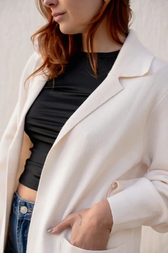 Femme portant un maille oversize cosy chic avec blazer léger et jeans bleus