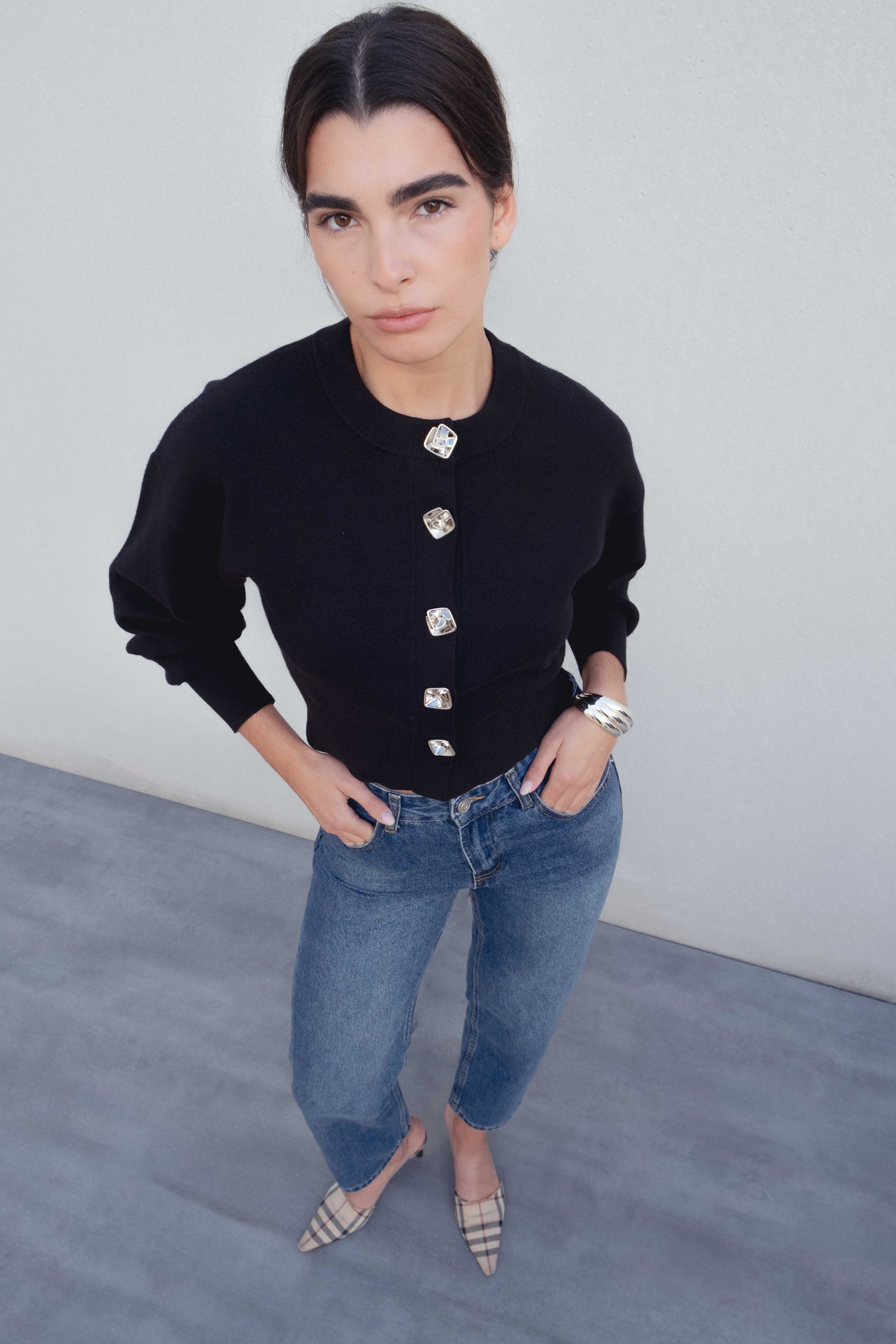 Cardigan femme noir boutonné cintré, porté par une femme avec des jeans, mettant en valeur son style élégant. Cardigan noir femme.