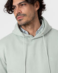 Détail de la capuche et des cordons du sweat vert pâle
