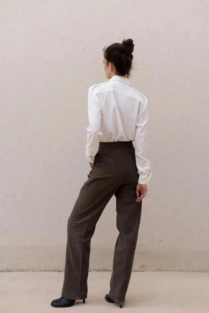 Femme portant une chemise blanche en soie à poches et pantalon foncé