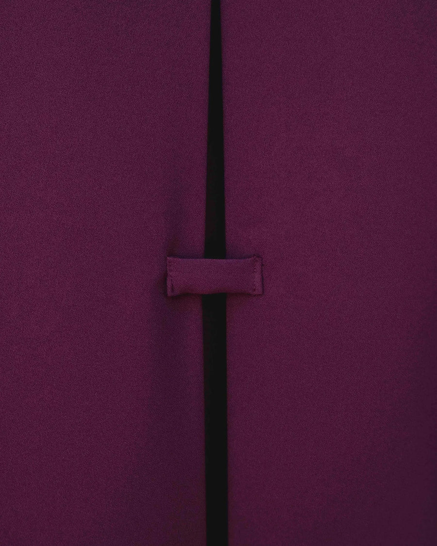 Détail de la fente à l'arrière de la chemise élégante bordeaux à boutons dorés pour femme, soulignant son design raffiné. Une excellente option pour une chemise bordeaux femme élégante.
