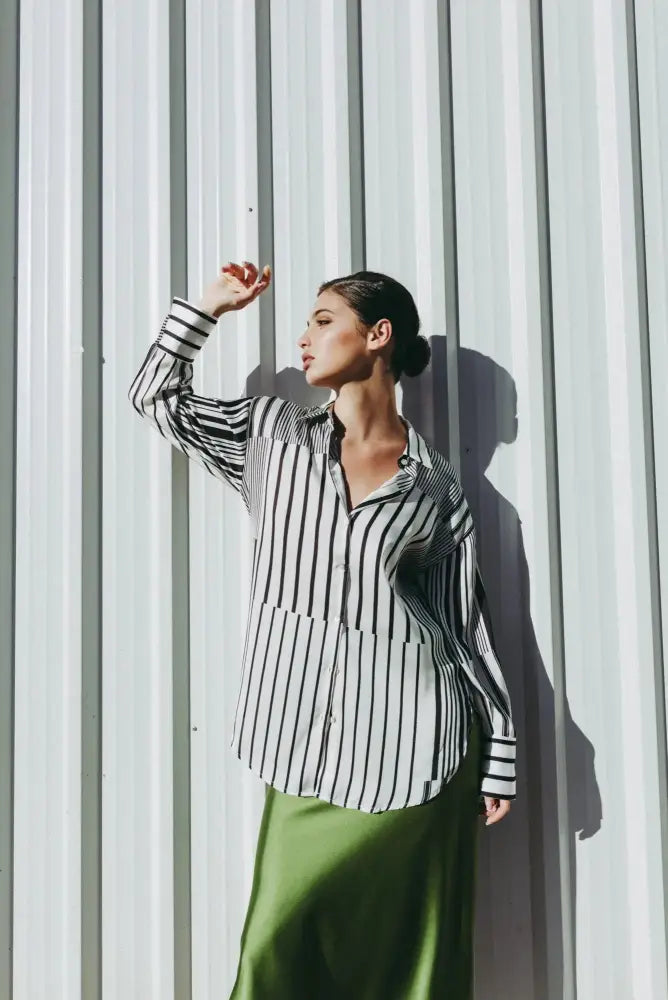 Femme portant une chemise imprimée rayures et une longue jupe satin olive verte