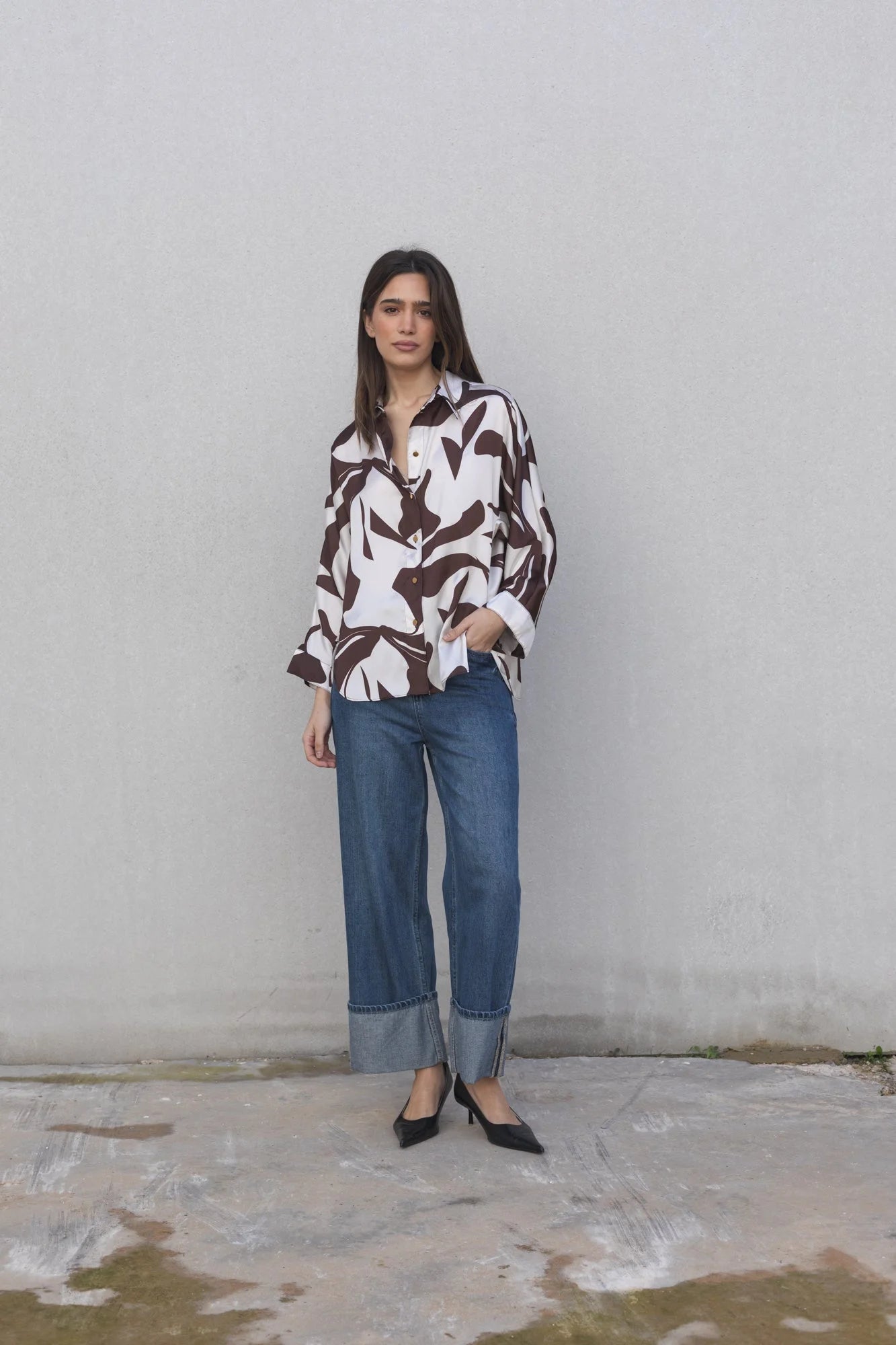 Chemise en satin imprimée à motif abstrait portée avec jeans et talons noirs