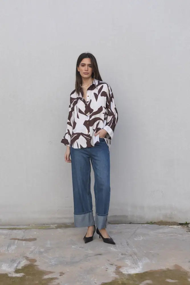 Chemise en satin imprimée à motif abstrait portée avec jeans et talons noirs