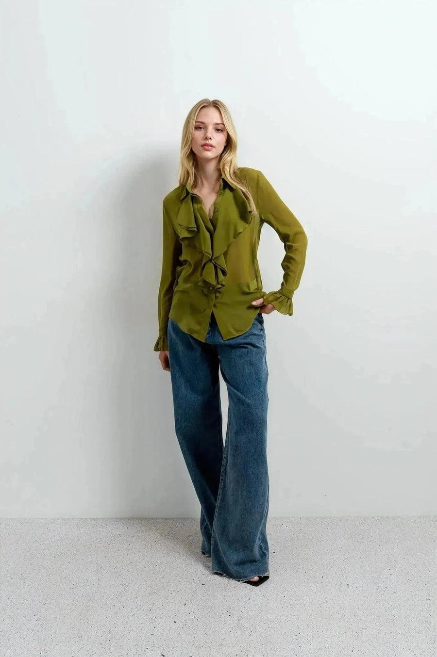 Chemise Femme à Volants Chic Vert Olive, un chemisier à volants femme présenté par un modèle qui affiche une pose décontractée sur fond clair.