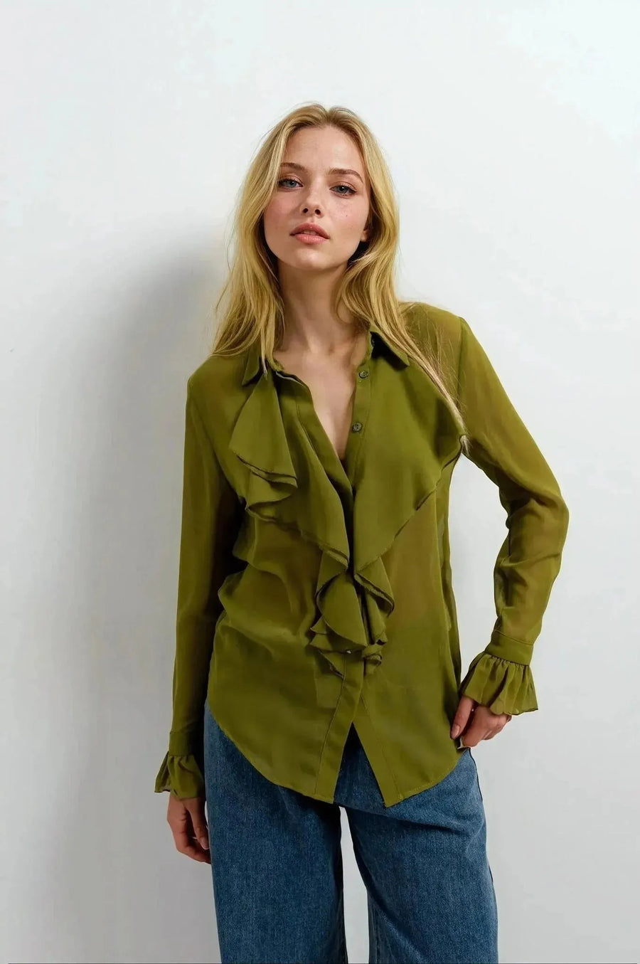 Chemise Femme à Volants Chic Vert Olive, un chemisier à volants femme mis en avant par un modèle avec un sourire, montrant les détails raffinés du vêtement.