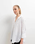 Chemise Femme Blanche Ample en popeline, style décontracté, portée par un modèle en studio avec un fond neutre.
