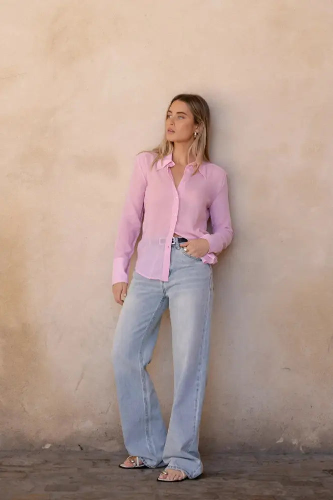 Femme portant une chemise flanelle rose clair et jeans taille large, style tendance