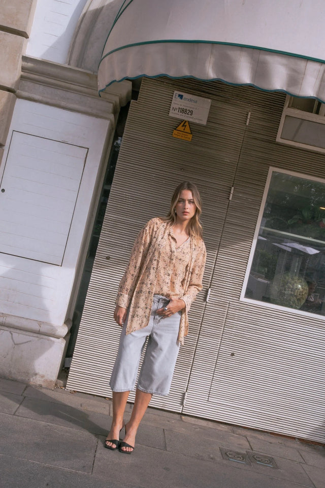 Femme portant une chemise fluide florale bohème chic avec tenue plus et sandales noires