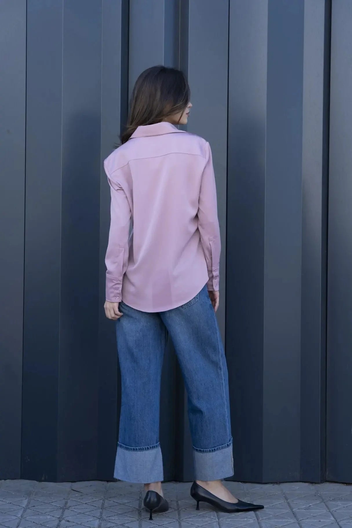Femme portant une chemise fluide lilas, jeans bleu et talons noirs