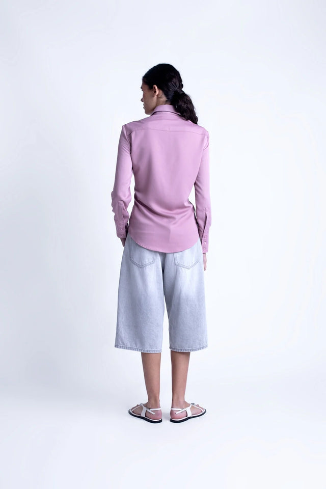 Vue arrière d'un modèle portant la chemise fluide femme lilas à col pointu avec des culottes pour un style chic et décontracté.