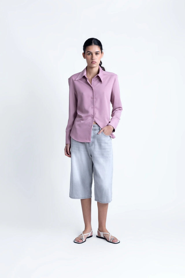 Modèle portant la chemise fluide femme lilas à col pointu avec des culottes, un choix polyvalent pour diverses occasions.